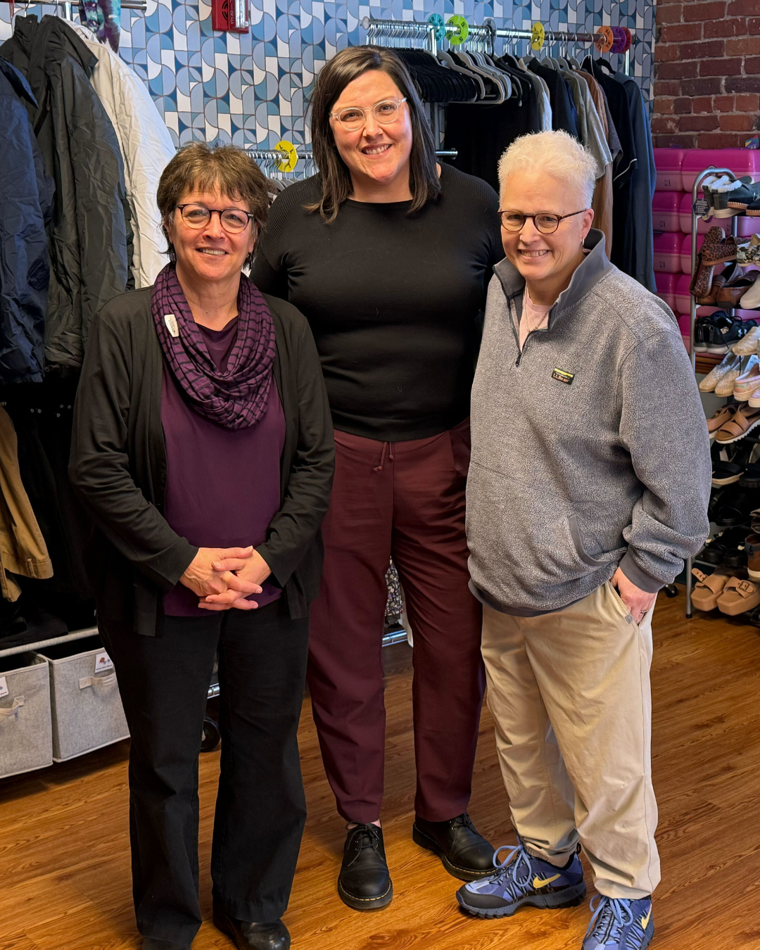 Three people standing in front of the Transhealth community closet. On the left is State Rep. Mindy Domb, the middle is Celia Overby, and the right is Jo Erwin.